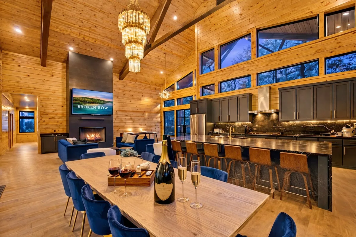 Great room at The Compound with a blue velvet sectional and floor-to-ceiling windows