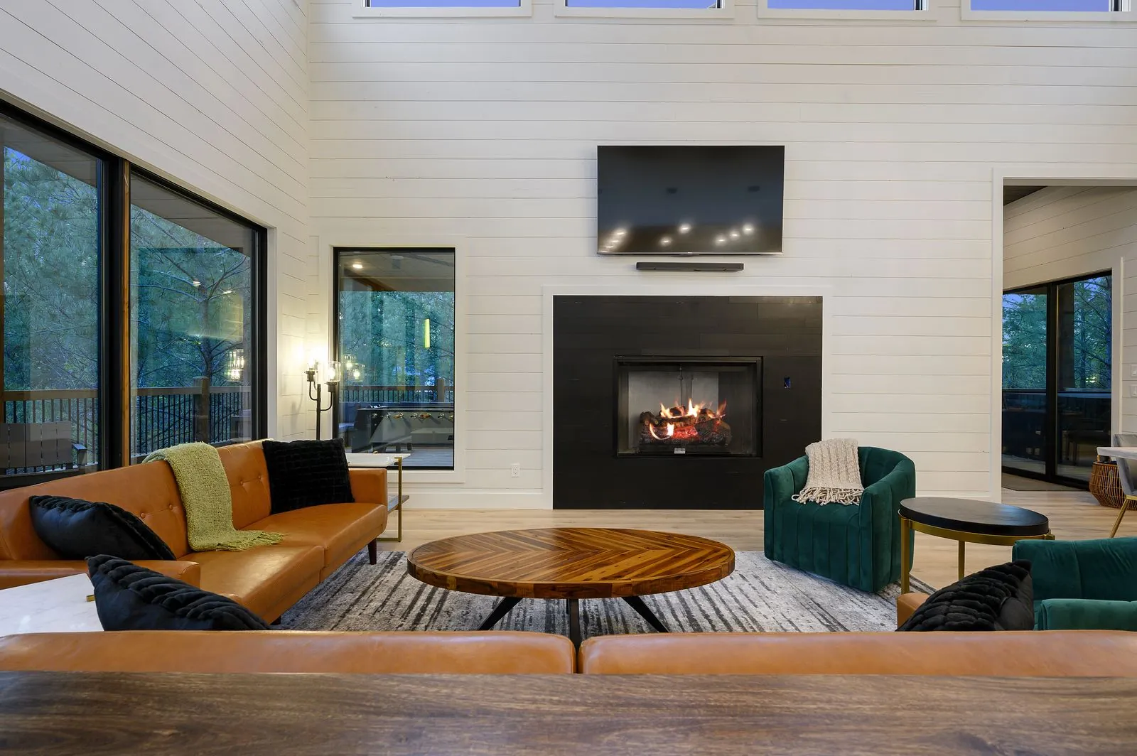Designer living room at The Arcadia with camel leather sofas and emerald green chairs, a Broken Bow bachelorette favorite