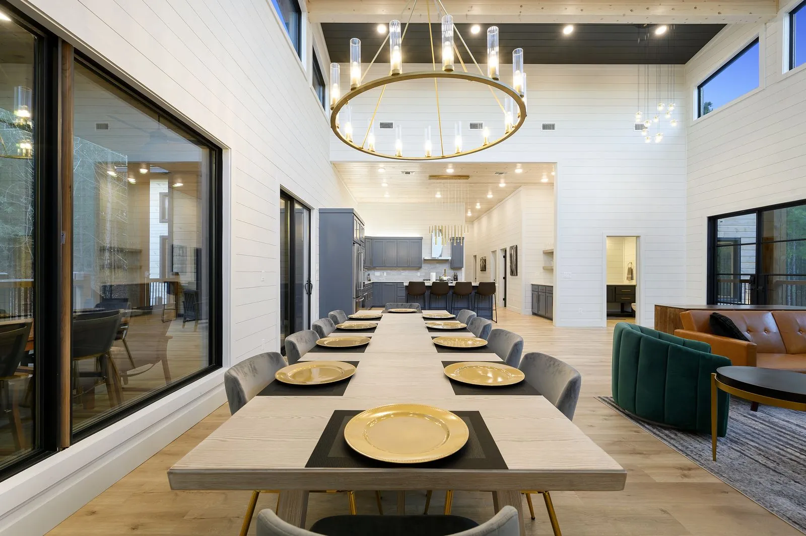 Kitchen at The Arcadia from elevated angle showing island with bar stools and gray cabinets under wood ceiling