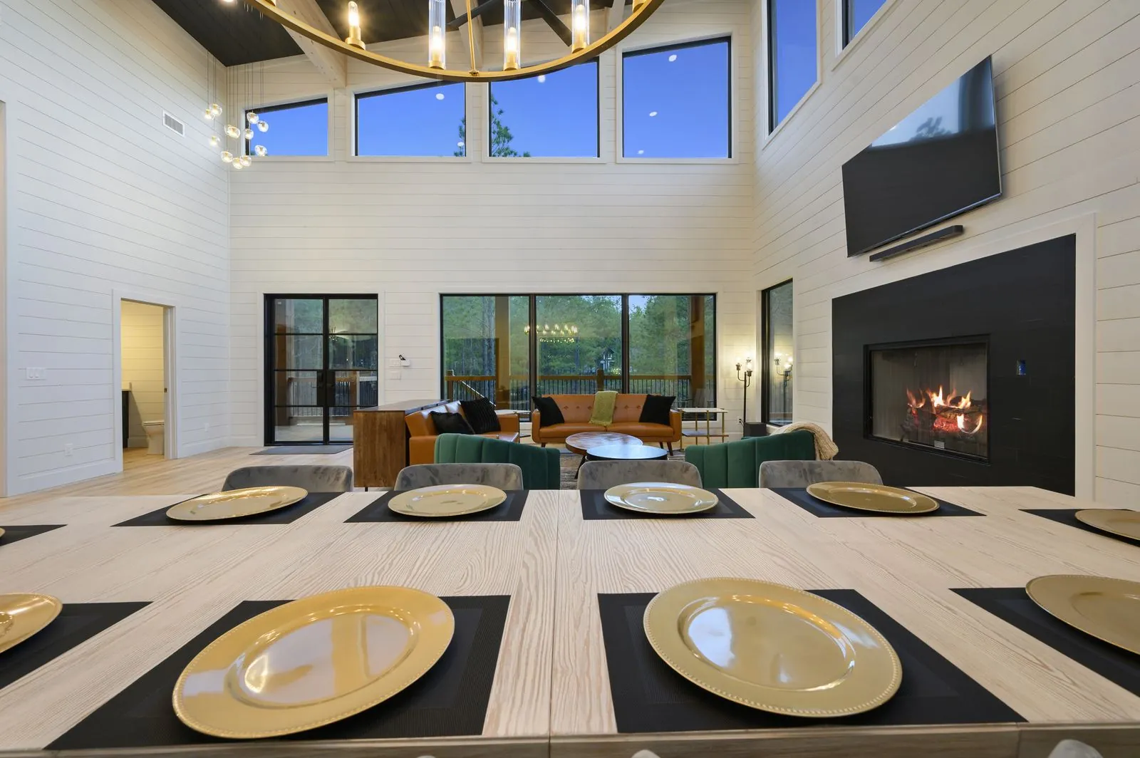 Playing card suit artwork on shiplap wall near glass doors with forest views at The Arcadia