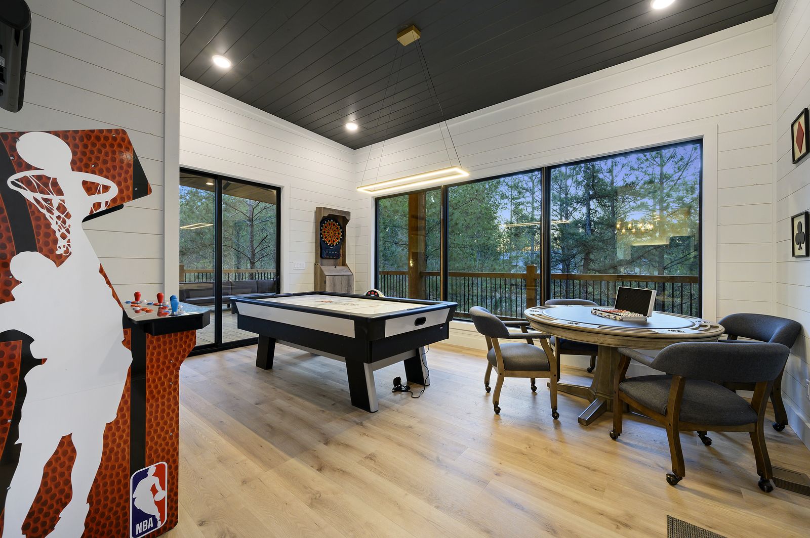Game room at The Arcadia with air hockey table, dark vaulted ceiling, and LED strip lighting