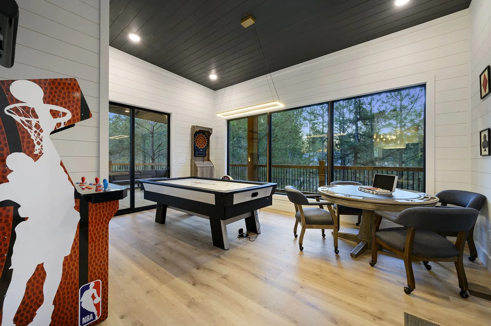 Game room at The Arcadia with air hockey table, dark vaulted ceiling, and LED strip lighting