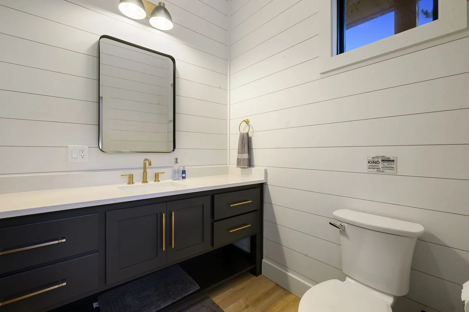 Bathroom at The Arcadia with tub-shower combo, hexagonal tile accent wall, and glass enclosure
