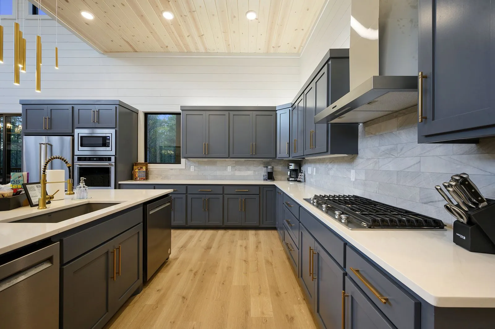 Kitchen at The Arcadia showing gray cabinetry, coffee station area, and shiplap walls with horse artwork