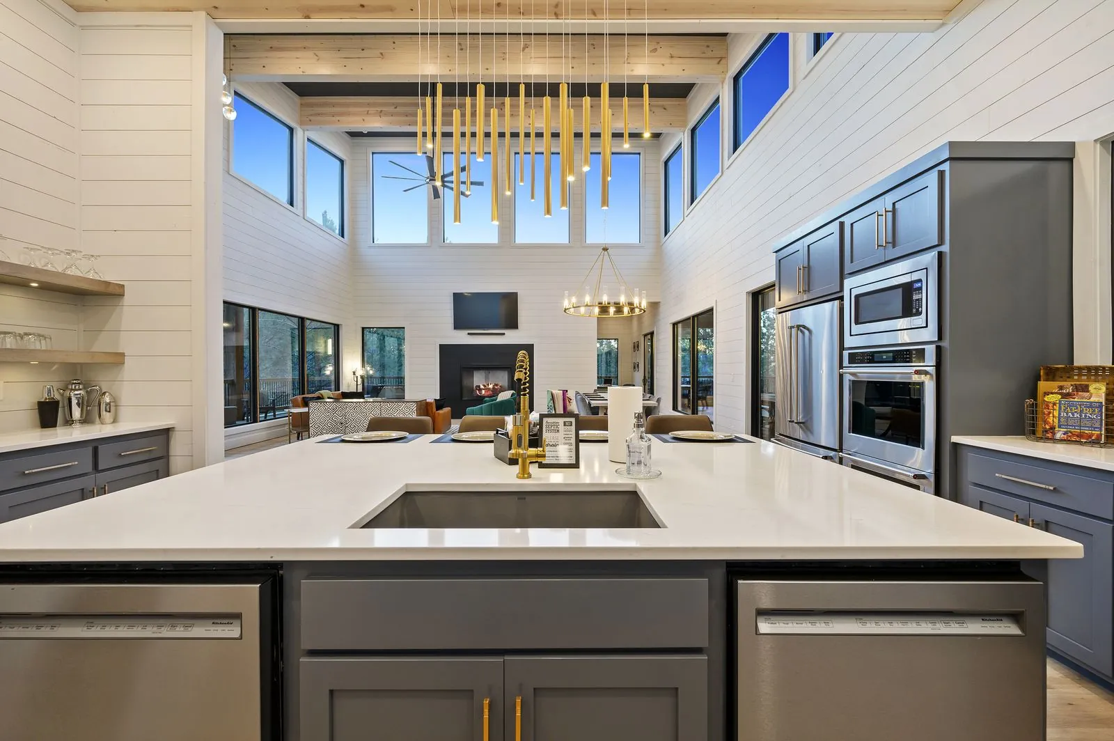 Kitchen at The Arcadia with gray island, white quartz countertops, and gold ring chandelier