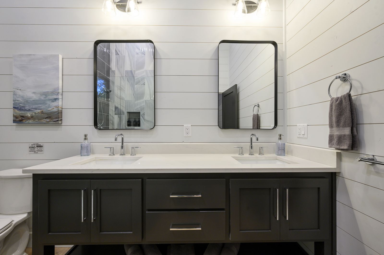 Walk-in shower at The Arcadia with dark and marble swirl tile, glass enclosure, and built-in niche