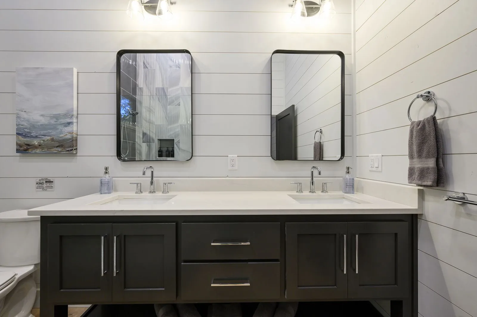 Walk-in shower at The Arcadia with dark and marble swirl tile, glass enclosure, and built-in niche