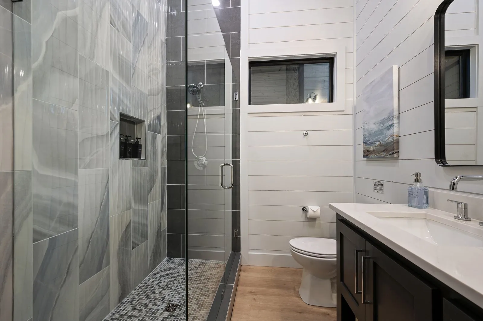 Walk-in shower close-up at The Arcadia showing dual showerheads and dark marble tile walls