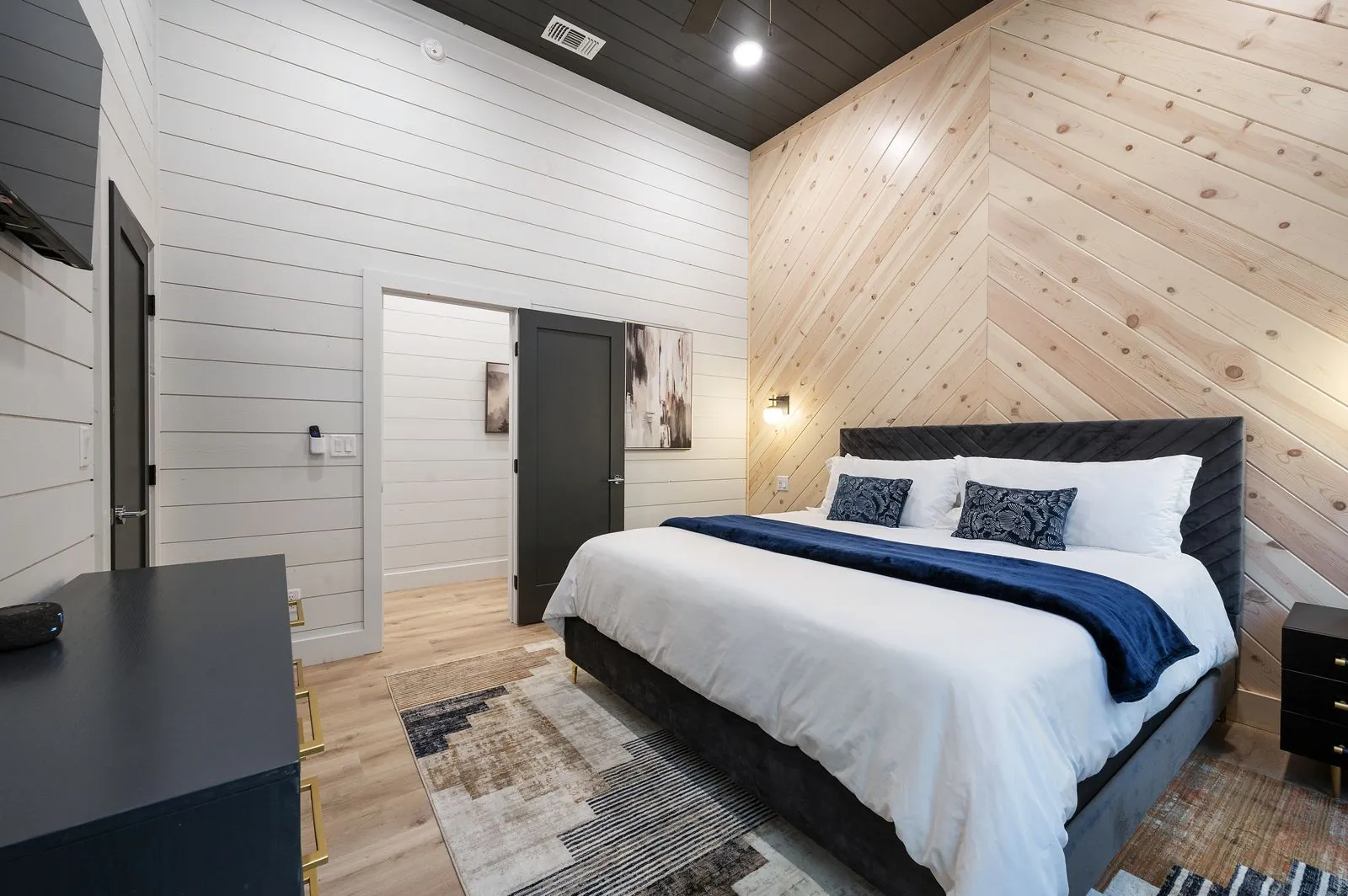 Bunk room at The Arcadia with dark metal frame built-in bunks, navy and white bedding, and bean bag chair