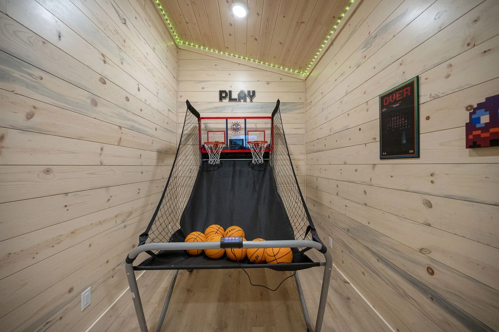 Indoor basketball shootout game with PLAY sign in wood-paneled game room at The Arcadia