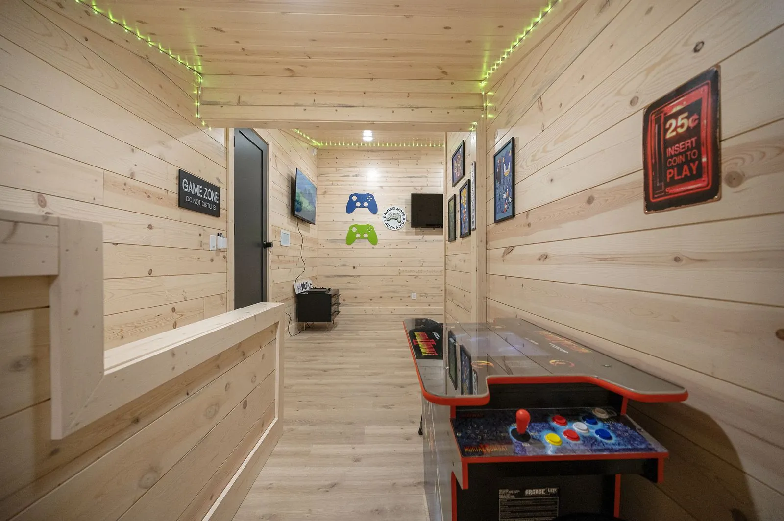 Warning May Yell at Video Games sign with butterfly chairs in wood-paneled game room at The Arcadia
