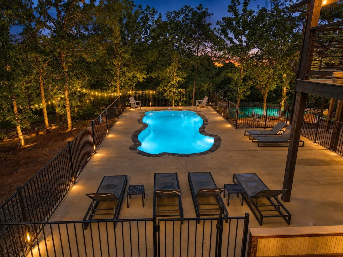 The Aroha's private heated pool and rear deck illuminated at dusk