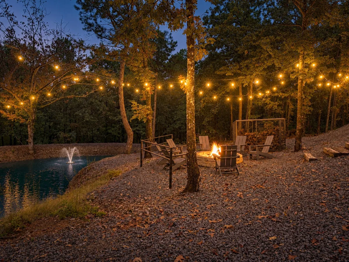 Private pond and fire pit illuminated at night at The Aroha