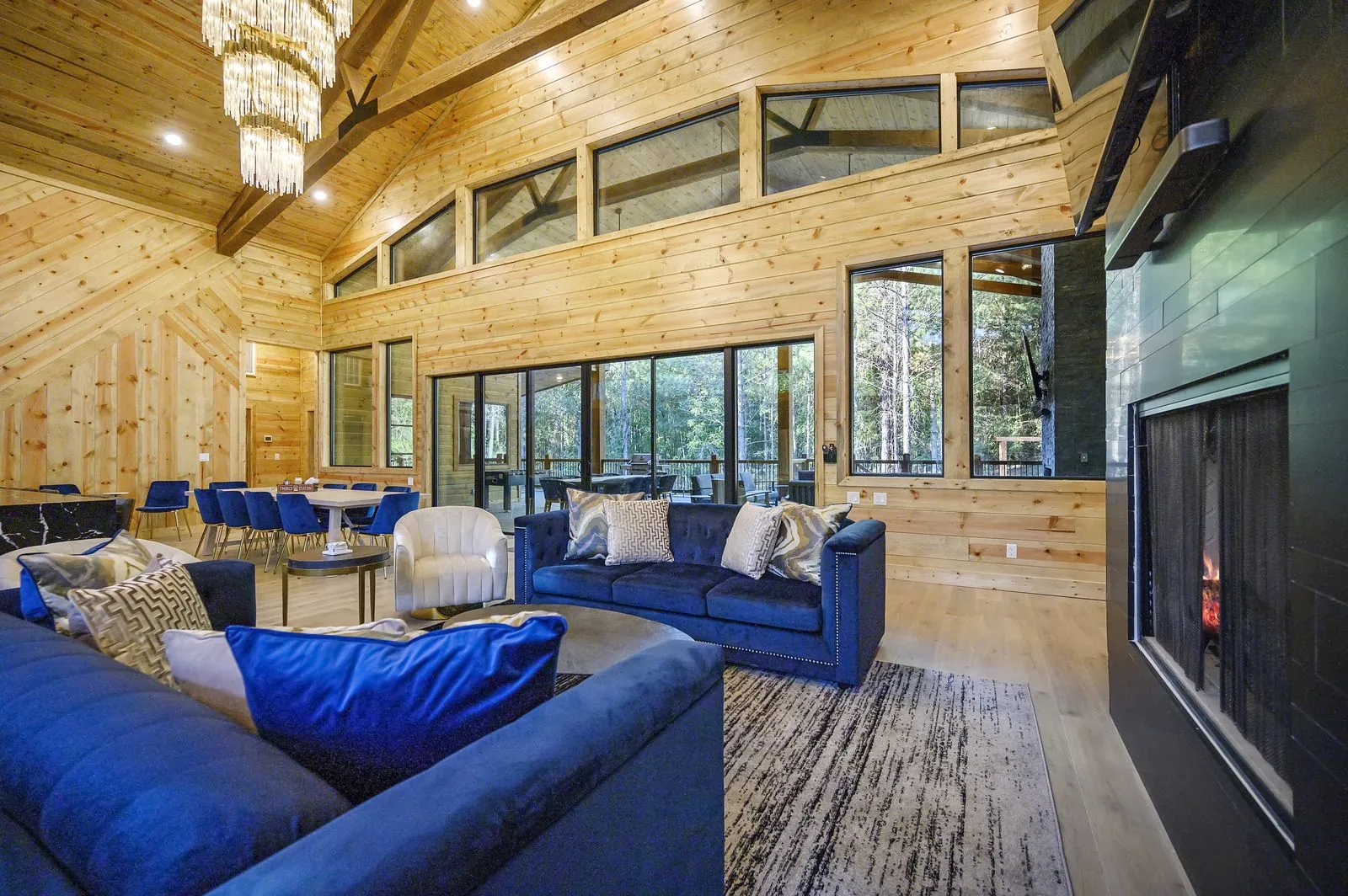 Great room at The Avalon with a blue velvet sectional and vaulted pine ceiling