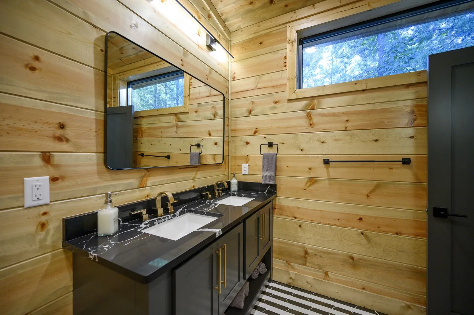 Full bunk room at The Avalon with multiple built-in bunks, wall-mounted TV, and dark accent wall