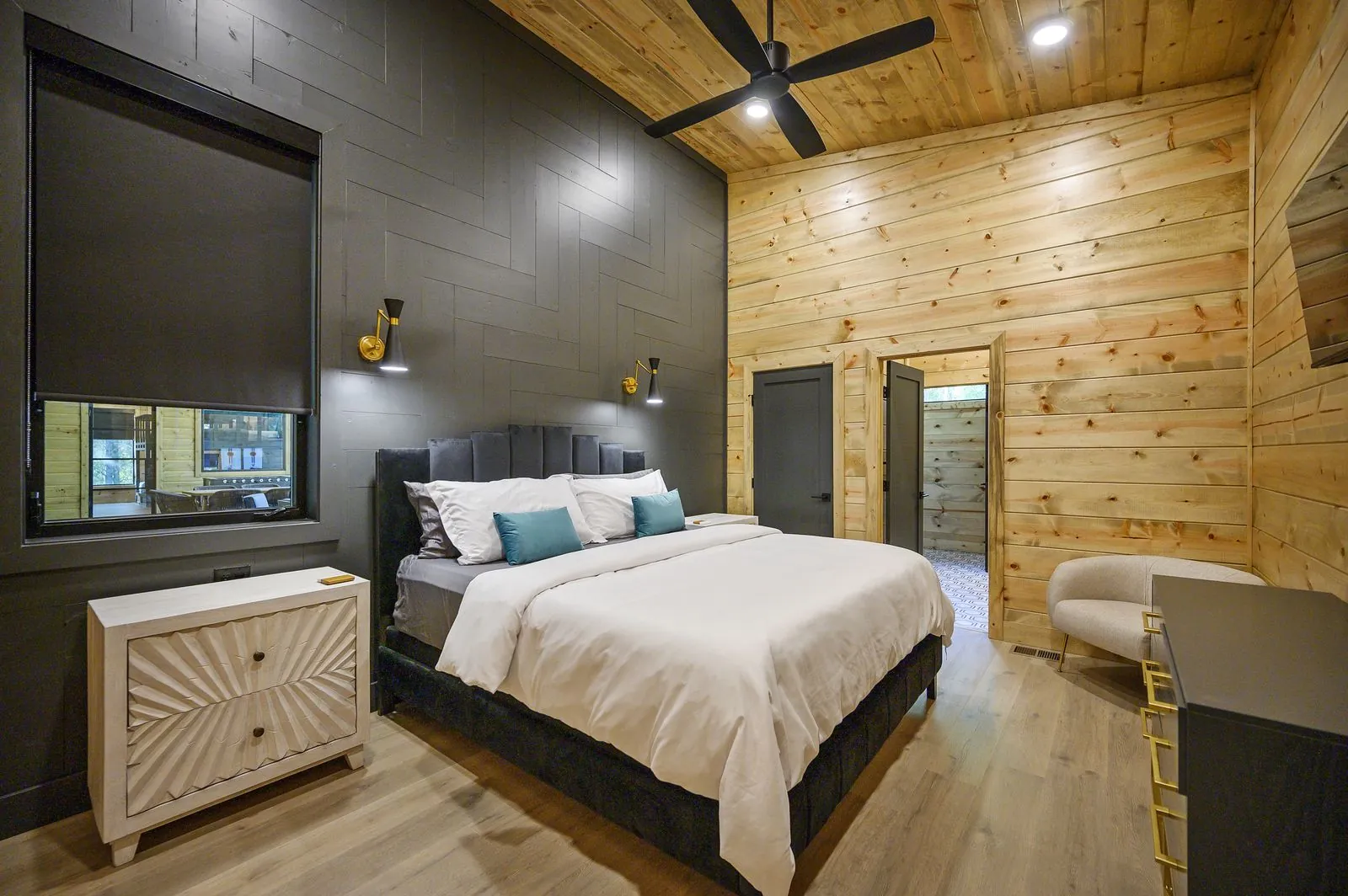 King suite 2 at The Avalon with an upholstered headboard and pine walls