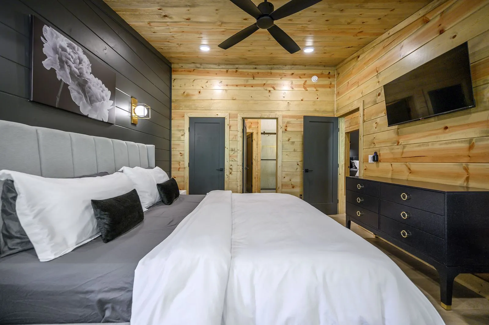 Bathroom showing vanity and open view to bedroom with king bed at The Avalon