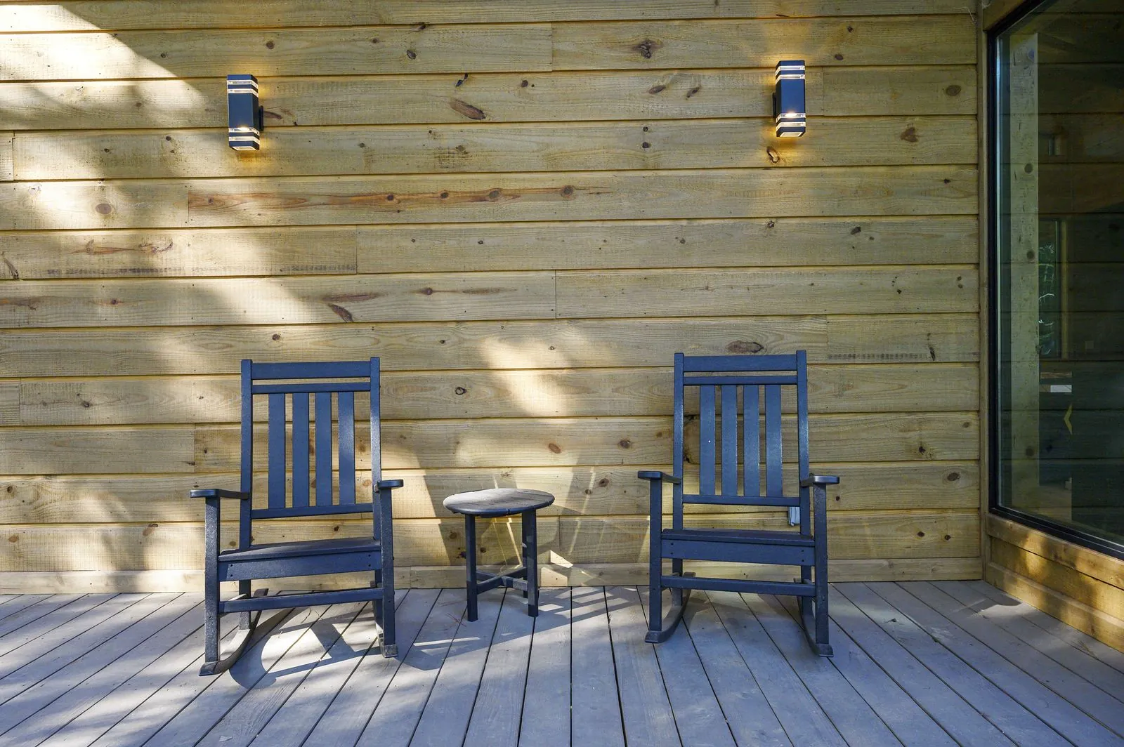Wooden cornhole boards with red, white, and blue design on the covered deck at The Avalon