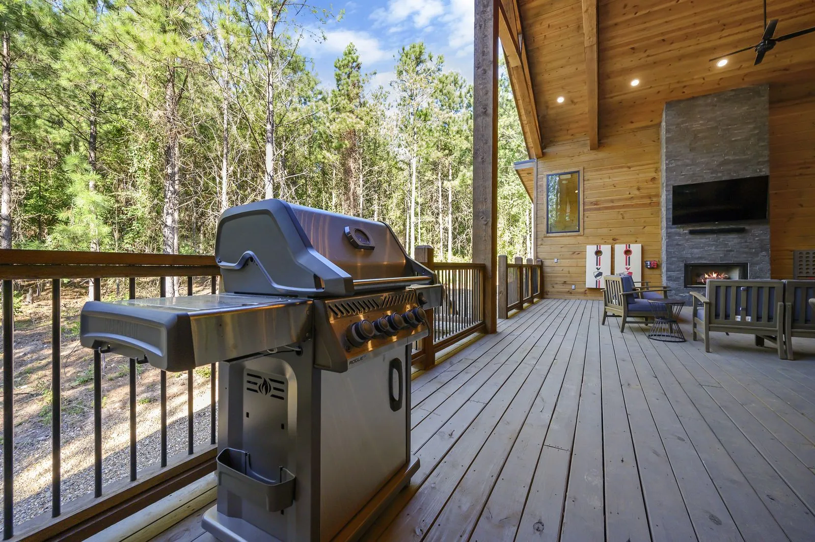 Outdoor entertainment area at The Avalon with covered seating, hot tub, and forest views