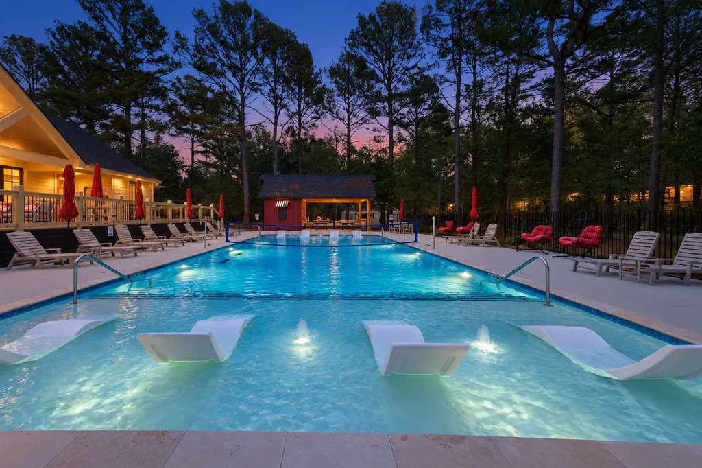 The Black-Beary — A shared resort pool with sunken in-water loungers, a volleyball net, and a poolside cabana, included at no extra cost.