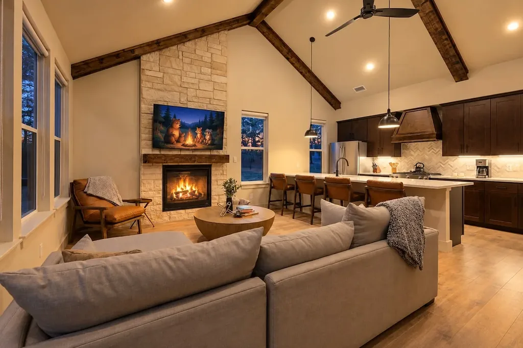 Dolce Far Nient — Gather by the stone fireplace in a soaring beamed living room that flows straight into the open kitchen.