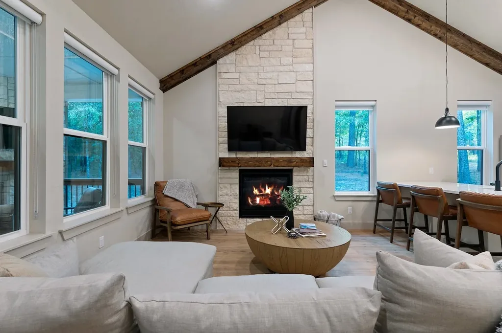 Dolce Far Nient — Gather around the stone fireplace beneath soaring wood-beamed ceilings and floor-to-ceiling forest views.