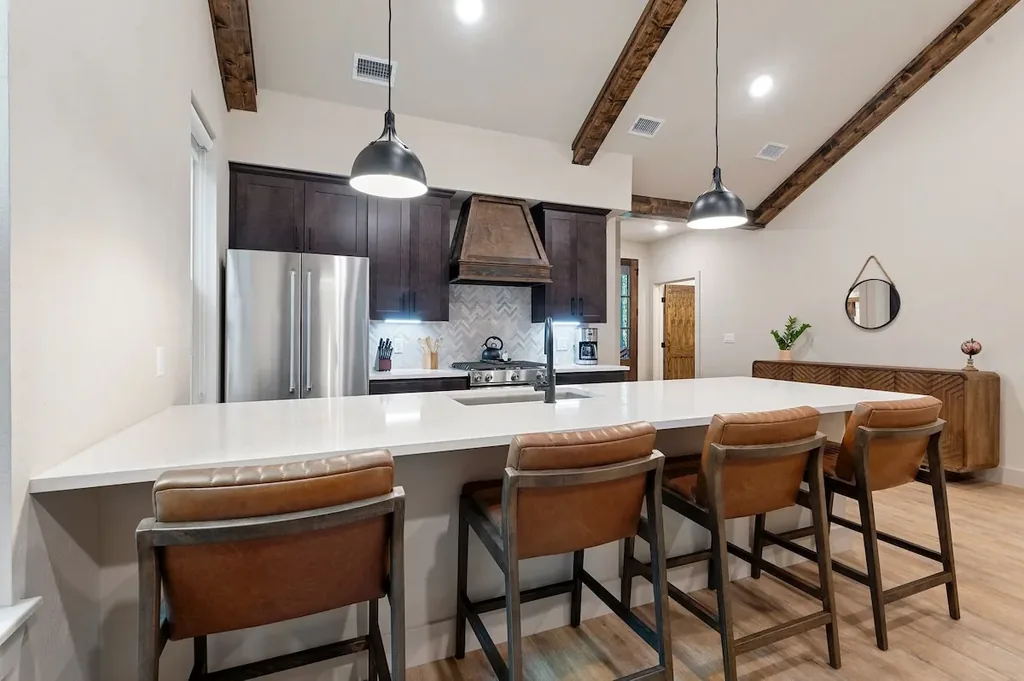 Dolce Far Nient — A spacious quartz island with counter-height seating for four makes this kitchen easy to cook and gather in.