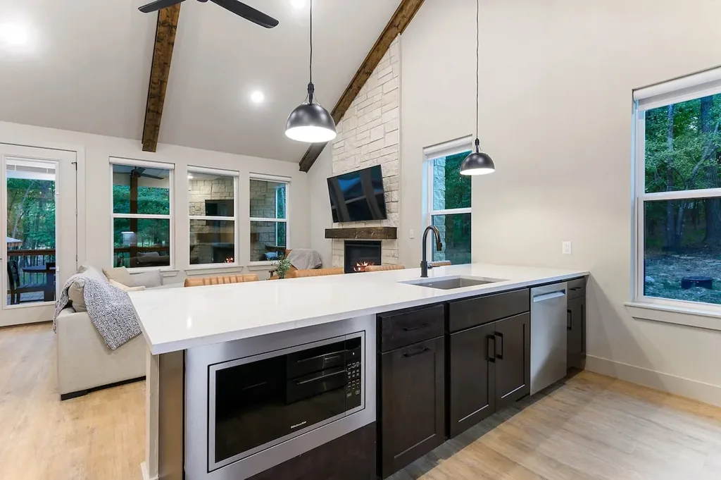 Dolce Far Nient — An open-concept kitchen island with quartz counters and stainless appliances keeps you connected to the fireplace and living space while you cook.
