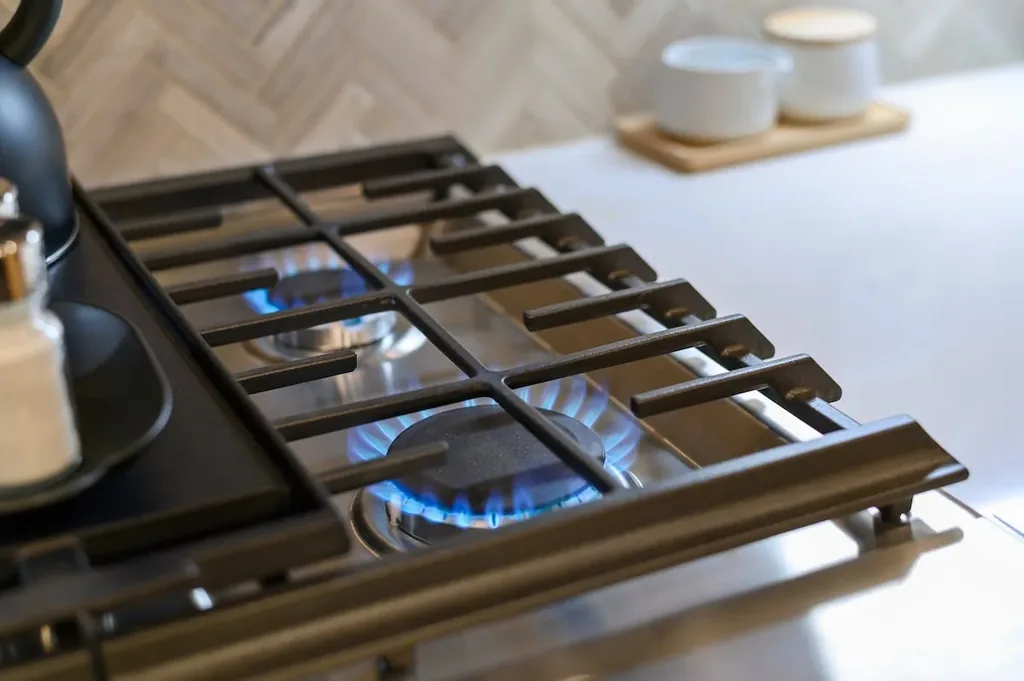 Dolce Far Nient — A gas cooktop with two burners lit, part of the private full kitchen. Guests can cook meals using the stovetop and adjacent counter space.