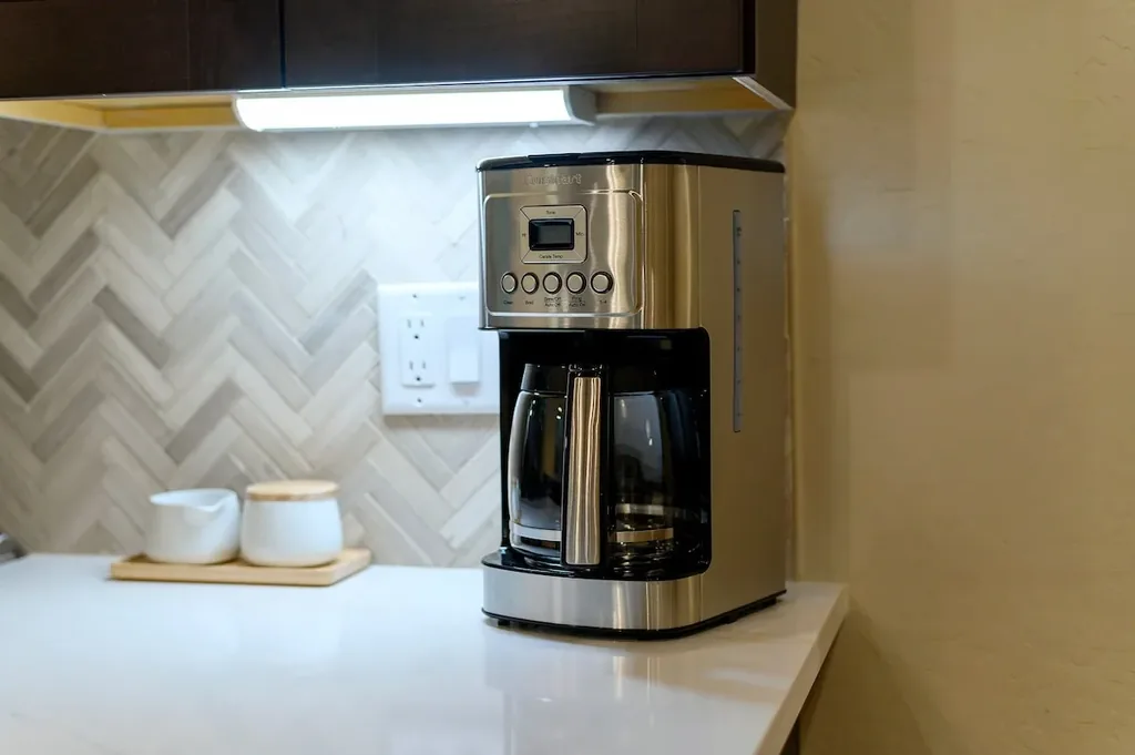 Dolce Far Nient — A stainless steel Cuisinart drip coffee maker sits on the kitchen counter, ready to brew a full pot for guests.