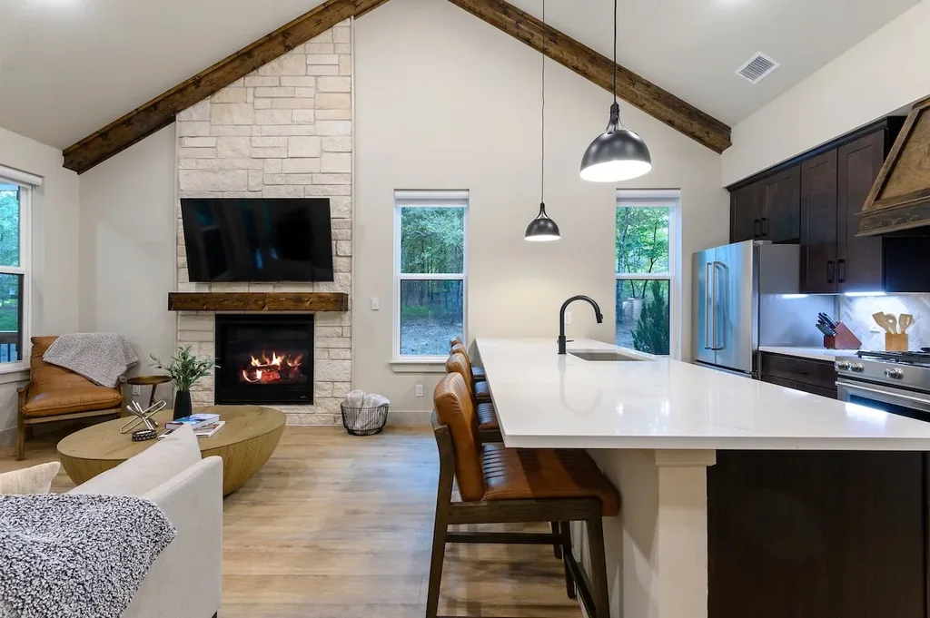 Dolce Far Nient — Gather around the stone fireplace or pull up a stool at the quartz island, all under soaring beamed ceilings in one open living space.