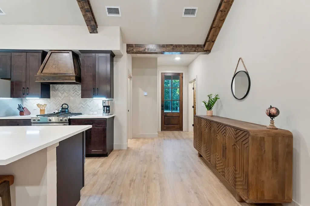 Dolce Far Nient — A fully equipped kitchen with a gas range and custom hood vent makes cooking easy before you relax in the beam-lined hallway beyond.