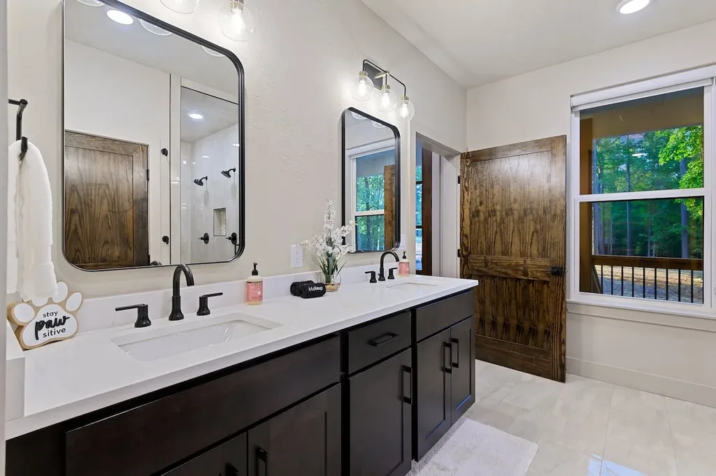 Dolce Far Nient — Get ready side by side at the double vanity, then step outside through the barn door to a private balcony surrounded by trees.