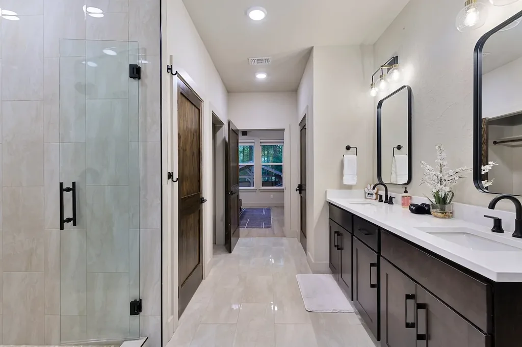 Dolce Far Nient — Get ready with ease at the dual-sink vanity beside a spacious glass walk-in shower.