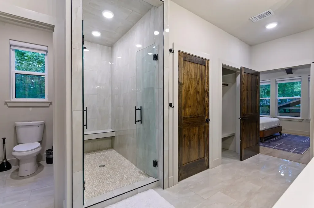 Dolce Far Nient — A spacious glass walk-in shower with a built-in bench makes this private bath feel like a retreat of its own.