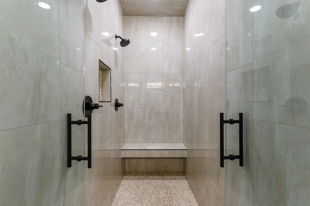 Dolce Far Nient — The oversized walk-in shower offers a rainfall showerhead and built-in bench for a spa-like rinse.