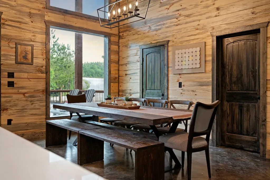 Indoor dining table beside the forest-view windows