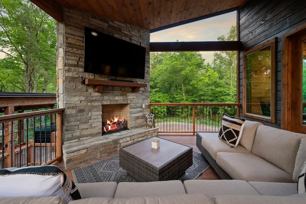 Covered outdoor living room with fireplace and television