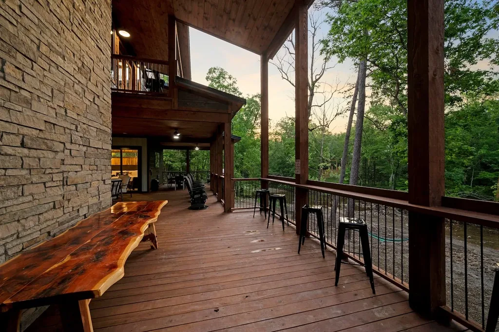 Creekside deck with a live-edge bar and stools