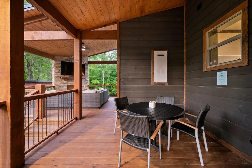Covered deck dining area beside the outdoor fireplace lounge