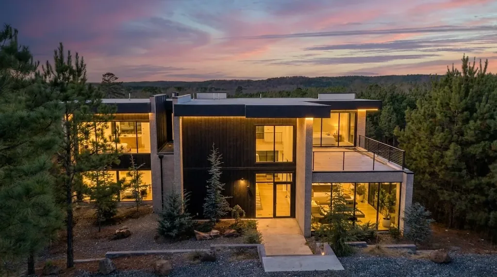 The Jade exterior illuminated at twilight in the Broken Bow forest