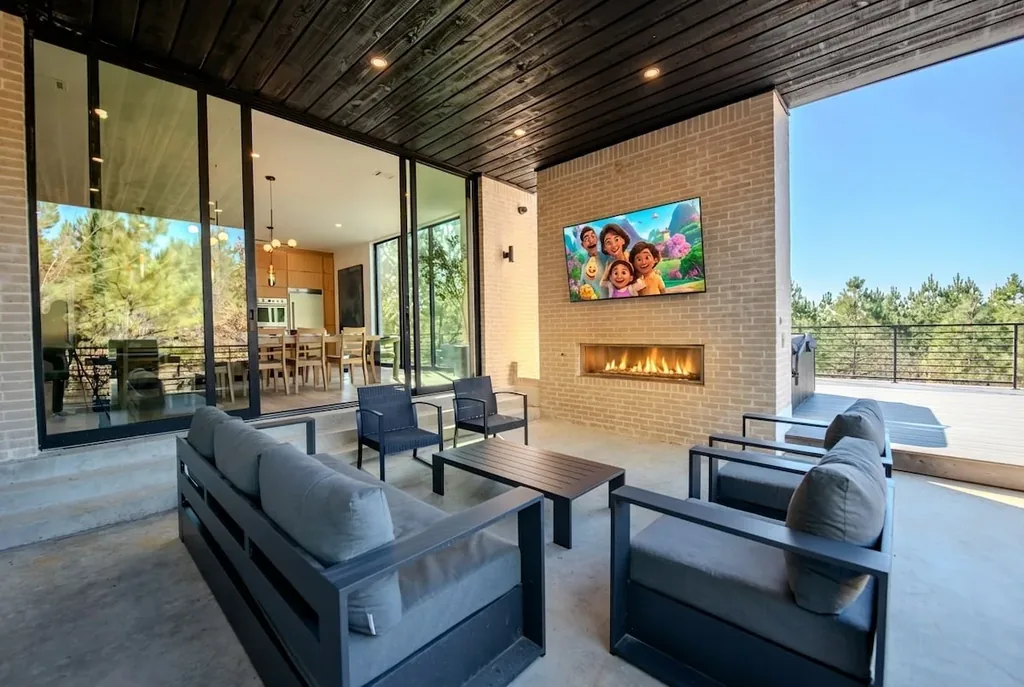 Covered outdoor living room with fireplace and television