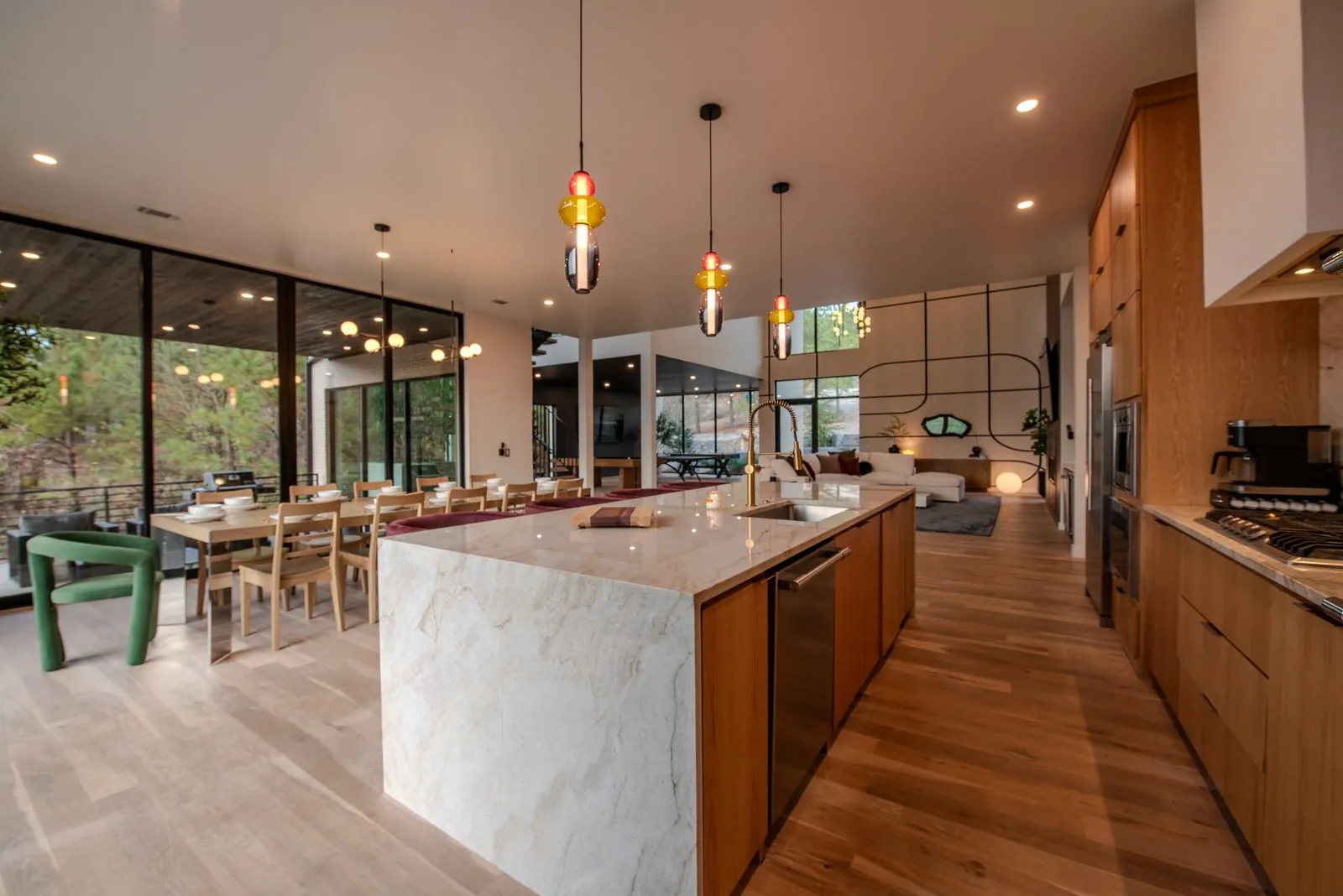 Full kitchen panorama at The Jade with large marble island, pendant lights, and open sightline to the dining area
