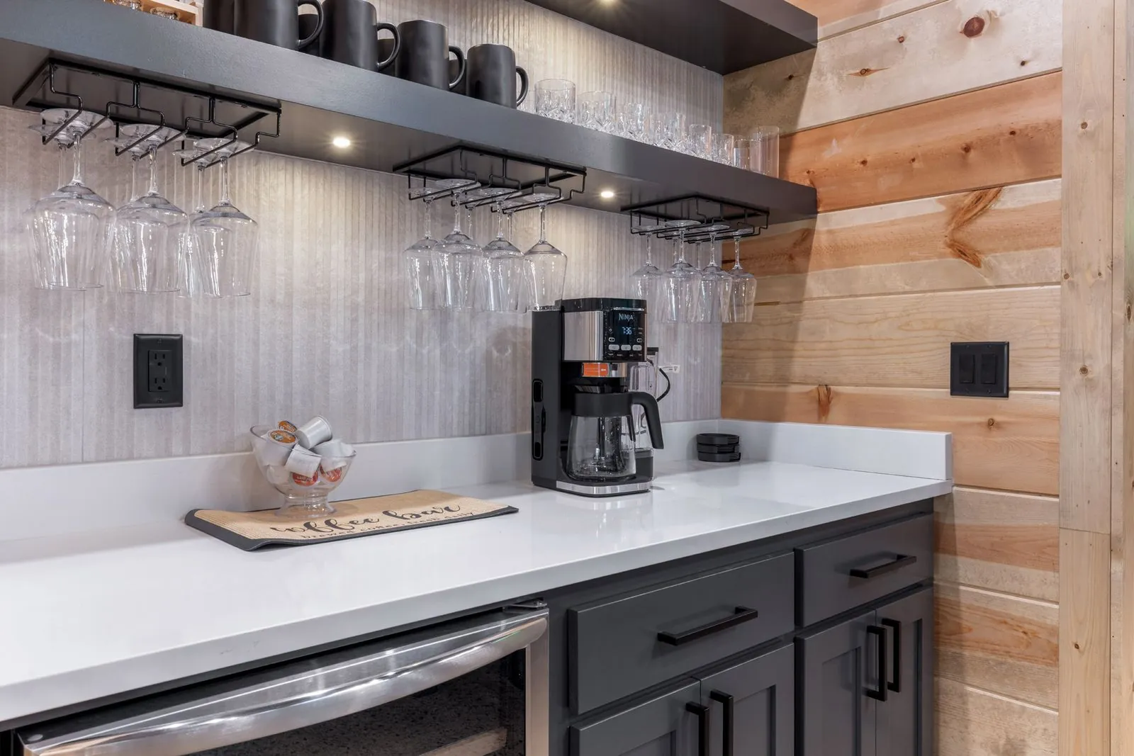 Kitchen at LivNLove with dark blue cabinetry, white quartz countertops, coffee station, and globe pendant lights