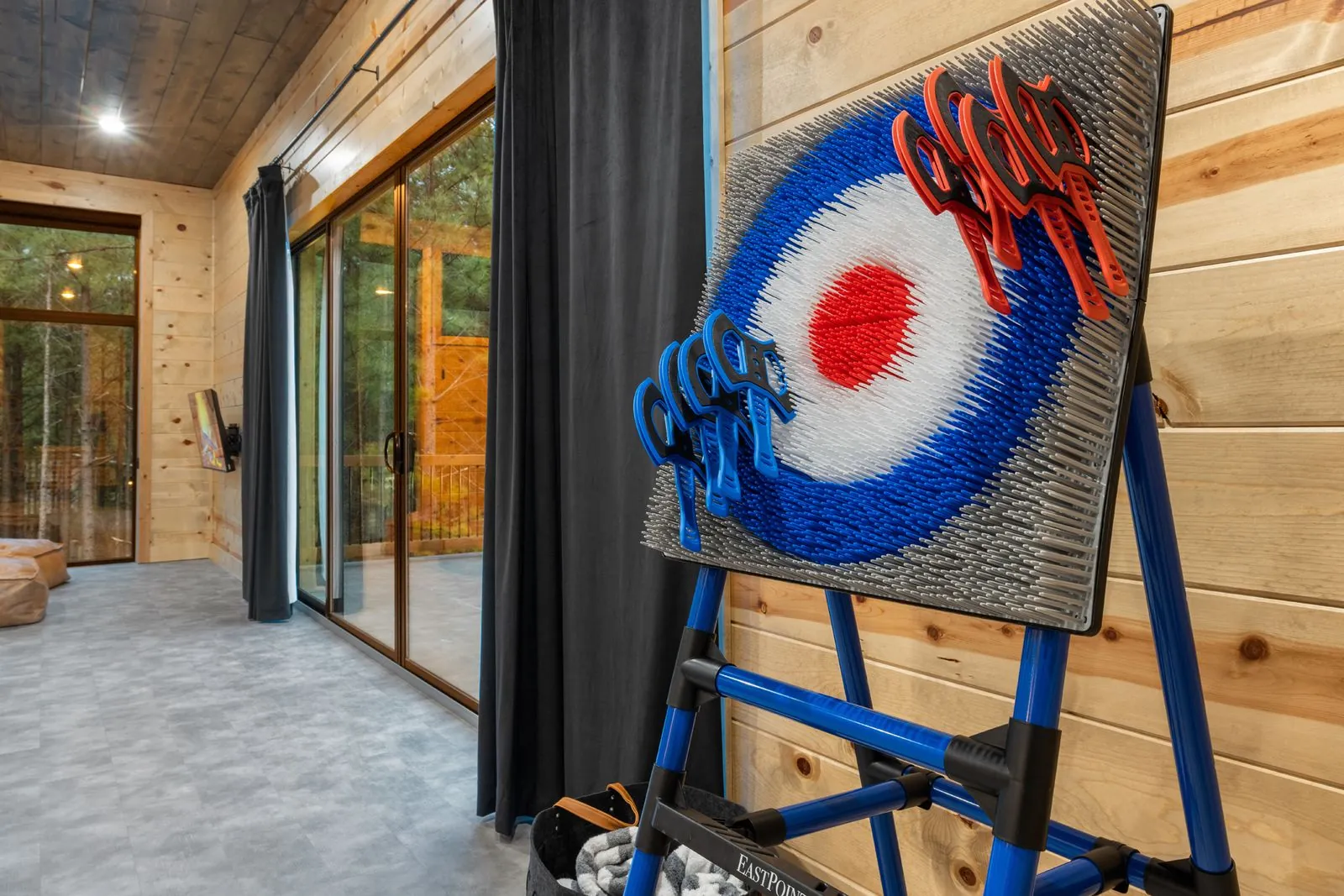 Axe-throwing target and dart board game setup in the recreation area at LivNLove