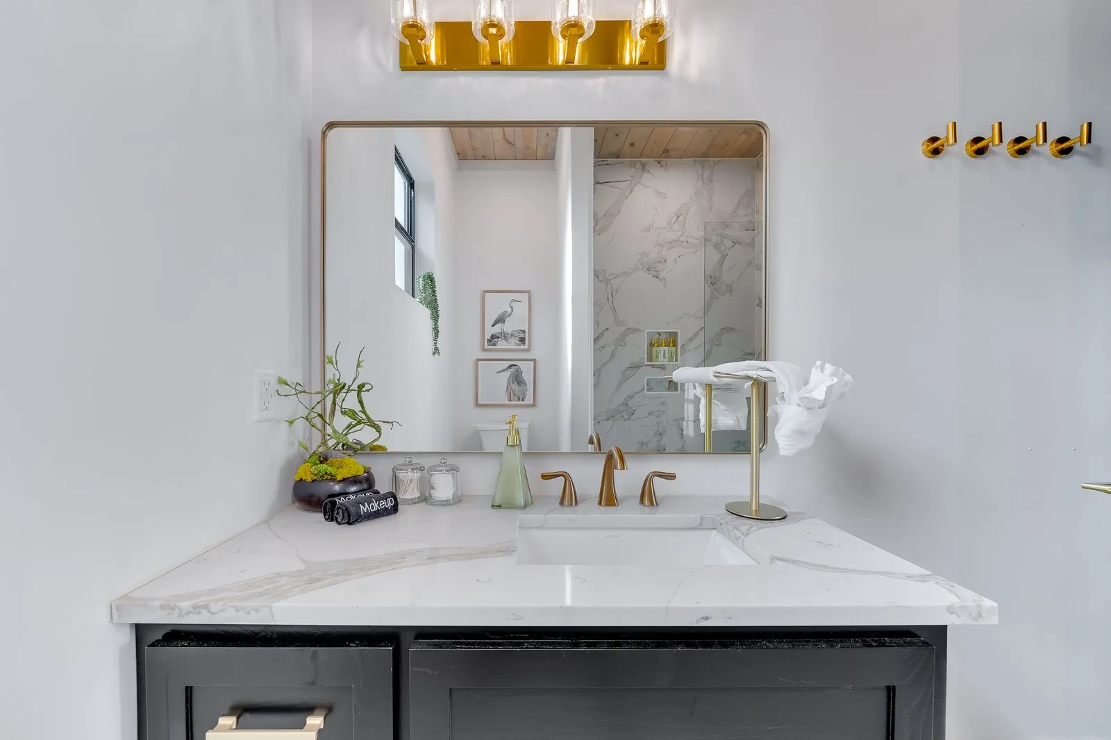 Bathroom at The Malibu with freestanding white soaking tub, framed mirror, dark accent door, and marble tile