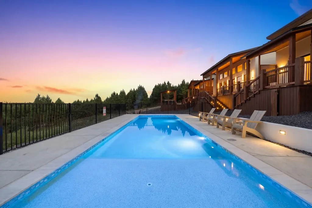 Private heated pool glowing at sunset beside The Malibu's multi-level deck
