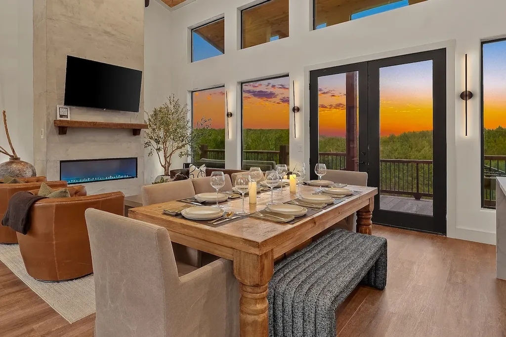 Dining table set beside the fireplace and sunset-facing windows