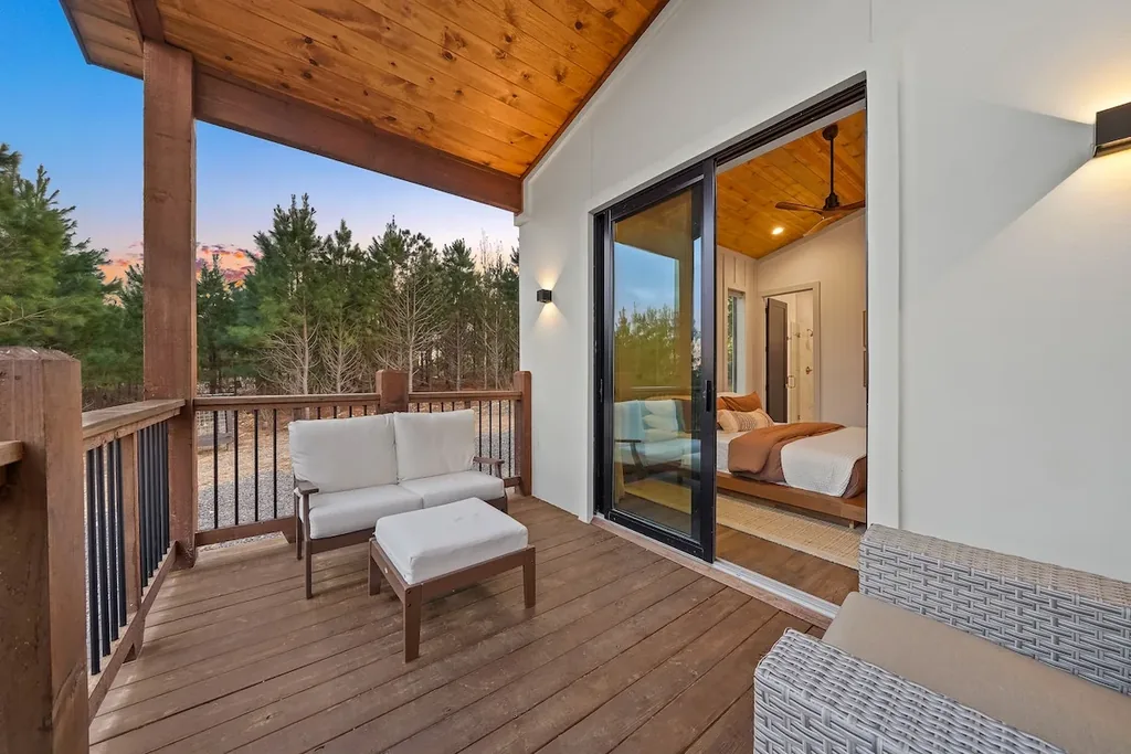 Private covered balcony outside King Bedroom 1 with forest views