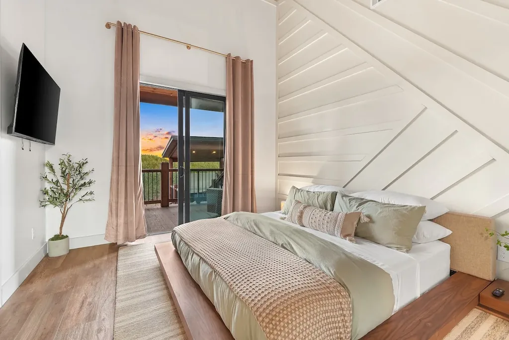 King Bedroom 3 with vaulted wood ceiling and sunset-facing balcony